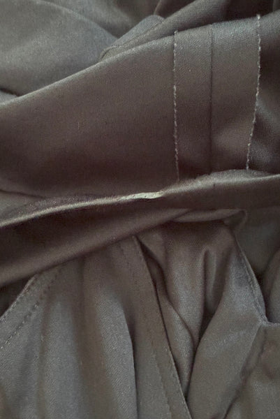 Hem detail view of vintage 1970s black knit strappy maxi dress, extra small to small. Showing melted spot on the hem.