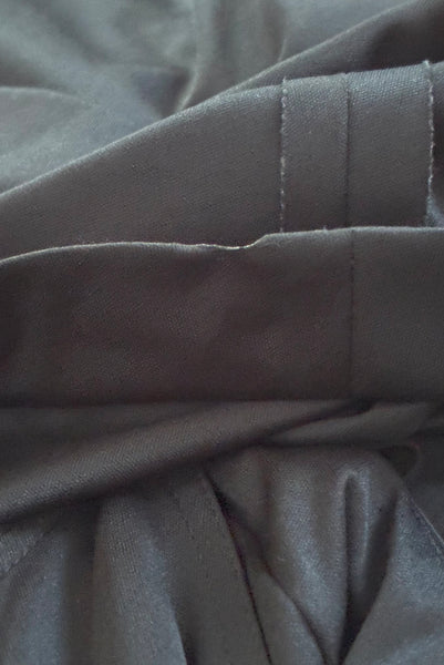 Hem detail view of vintage 1970s black knit strappy maxi dress, extra small to small. Showing melted spot on the hem.