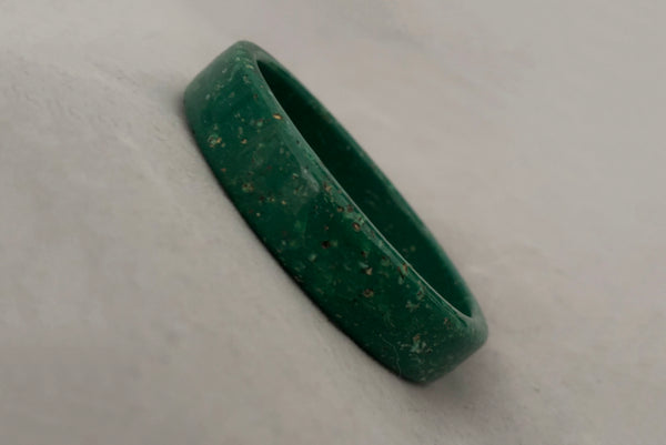 Horizontal perspective view of 1960s vintage green and white mottled textured two (2) sliced bangle bracelet set. Showing a single bangle.
