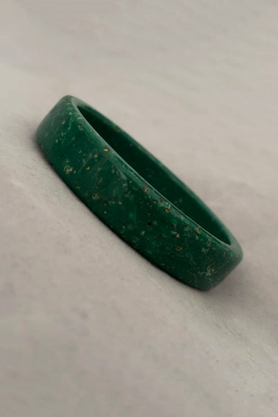 Vertical perspective view of 1960s vintage green and white mottled textured two (2) sliced bangle bracelet set. Showing a single bangle.