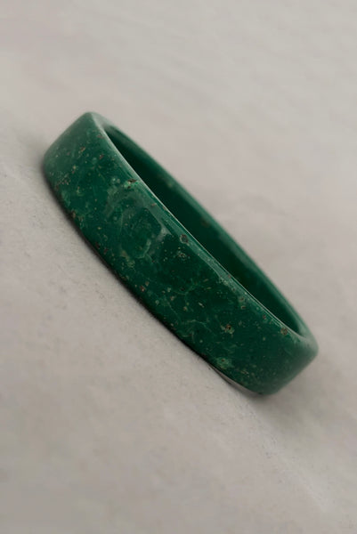 Vertical perspective view of 1960s vintage green and white mottled textured two (2) sliced bangle bracelet set. Showing a single bangle.
