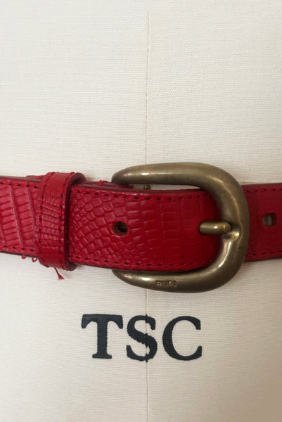 Detail view of 1980s vintage designer red stamped Italian leather belt  with brass buckle by Furla, size medium to large. Made in Italy. Showing a close-up of the brass buckle.