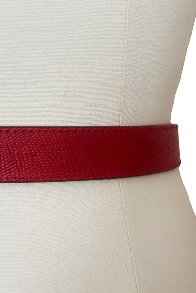 Detail view of 1980s vintage designer red stamped Italian leather belt  with brass buckle by Furla, size medium to large. Made in Italy. Showing a close-up of the textured leather.
