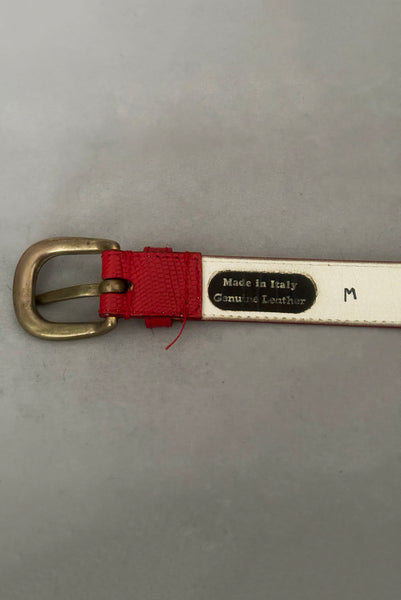 Interior detail view of 1980s vintage designer red stamped Italian leather belt  with brass buckle by Furla, size medium to large. Made in Italy. Showing a close-up of the Genuine Leather, Made in Italy and size M stamps.