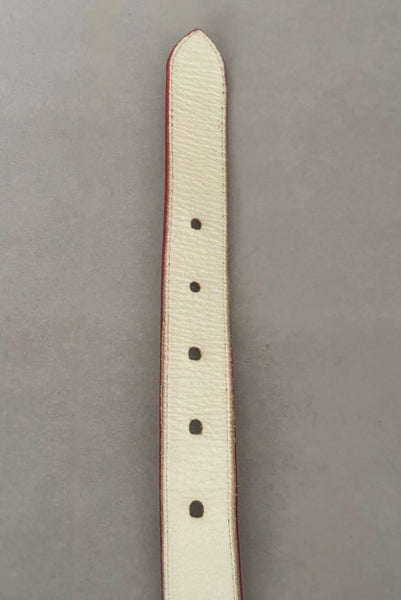 Interior detail view of 1980s vintage designer red stamped Italian leather belt  with brass buckle by Furla, size medium to large. Made in Italy. Showing a close-up of the belt holes.