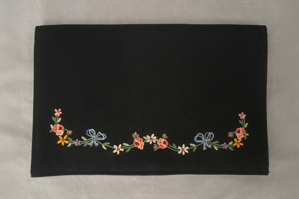 Horizontal front view of 1930s vintage black satin clutch with pink, blue, green, purple, and gold floral chainstitch embroidered clutch by Denis Francet.