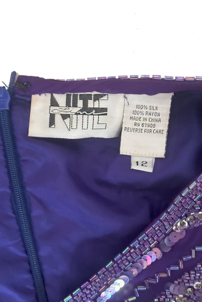 Interior top detail view of 1980s vintage beaded purple silk & rayon blouse and drop waist dress Set by Nite Line, small to medium. Showing the Nite Line label, fabric composition and size 12 tag.