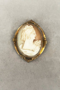 Vertical front view of 1920s vintage pink and white carved shell women's head figural carved cameo brooch pendant in 12k gold fill setting.