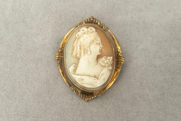 Horizontal front view of 1920s vintage pink and white carved shell women's head figural carved cameo brooch pendant in 12k gold fill setting.