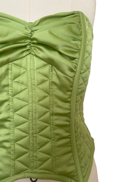 Front detail view of 1990s vintage peridot green quilted satin corset/bustier by John Festa, small to medium. New without tags. Showing the zig zag quilting pattern and gathered bust.