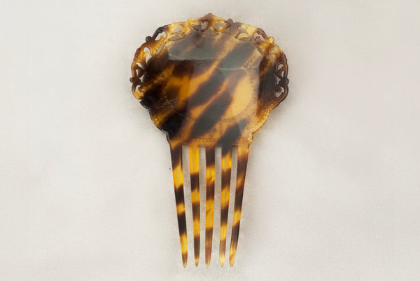 Horizontal back view of 1920s vintage early plastic marbled brown tortoise hair comb with clear, red, and blue rhinestones.