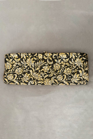 Vertical front view of 1960s vintage black, gold, and silver metallic floral brocade long evening clutch purse with foldout chain handle.