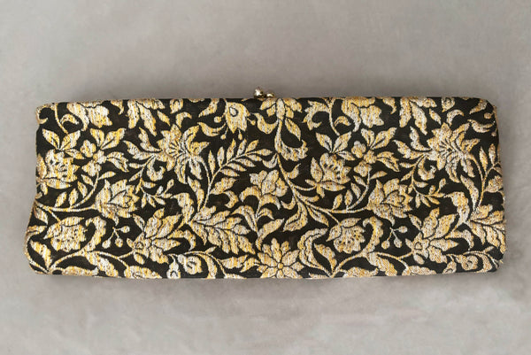 Horizontal front view of 1960s vintage black, gold, and silver metallic floral brocade long evening clutch purse with foldout chain handle.
