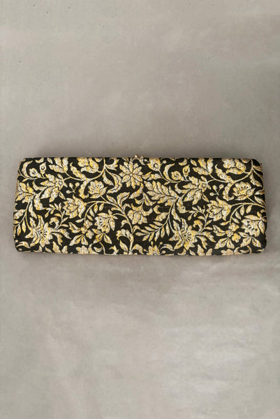 Vertical back view of 1960s vintage black, gold, and silver metallic floral brocade long evening clutch purse with foldout chain handle.