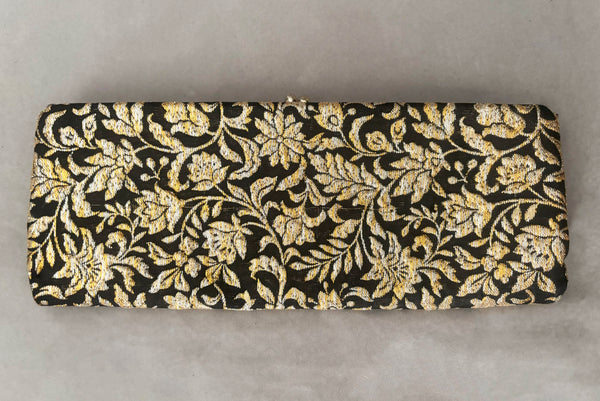 Horizontal back view of 1960s vintage black, gold, and silver metallic floral brocade long evening clutch purse with foldout chain handle.