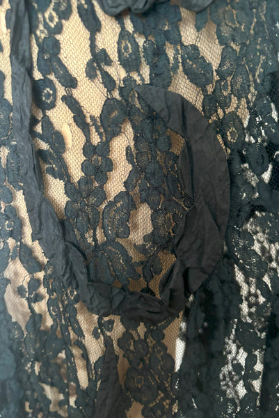 Detail view of 1990s vintage goth sheer black lace and taffeta nude look skirt, medium to large. Showing the black silk taffeta scalloped swirls on the embellished lace, and small breaks in the lace netting.