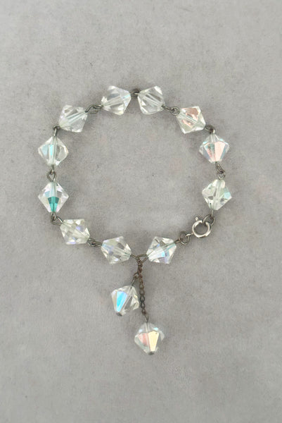 Vertical closed view of 1960s vintage iridescent crystal bicone bead and silver tone bracelet.