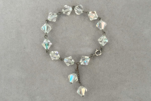 Horizontal closed view of 1960s vintage iridescent crystal bicone bead and silver tone bracelet.
