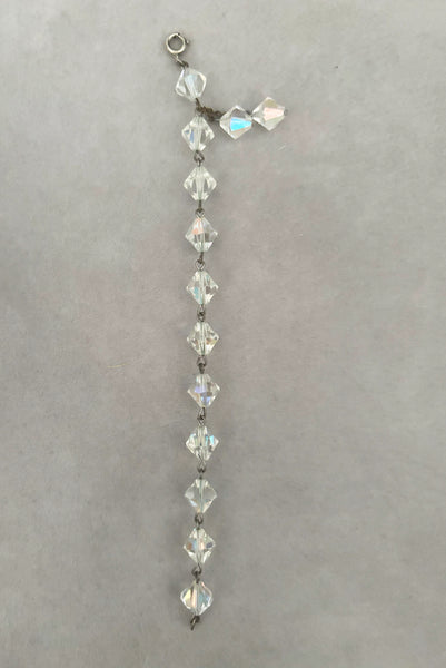 Vertical open view of 1960s vintage iridescent crystal bicone bead and silver tone bracelet.