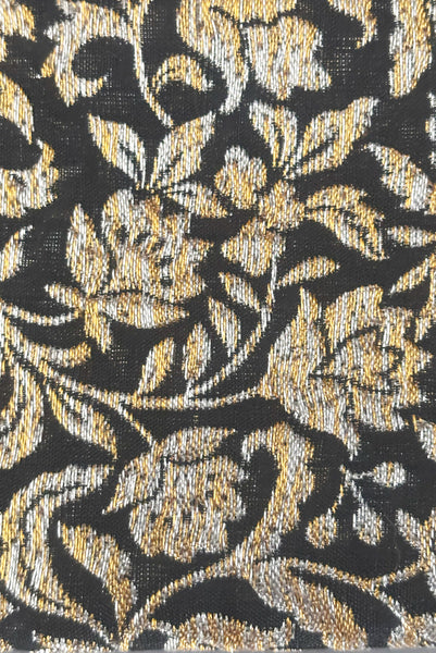 Front detail view of 1960s vintage black, gold, and silver metallic floral brocade long evening clutch purse with foldout chain handle. Showing a close-up of the metallic floral brocade. 