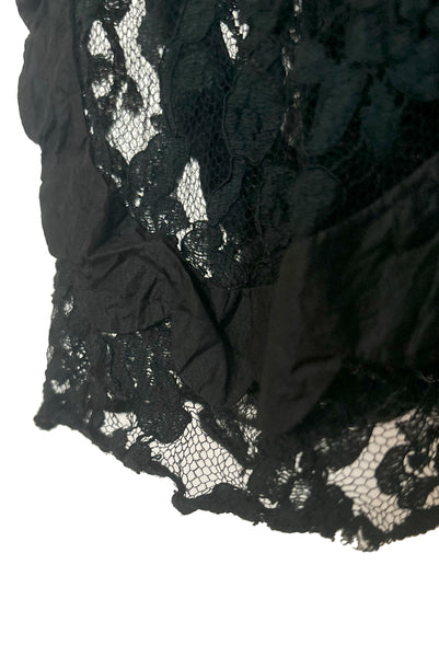 Hem detail view of 1990s vintage goth sheer black lace and taffeta nude look skirt, medium to large. Showing the black silk taffeta scalloped swirls on the embellished lace, and small breaks in the lace netting.