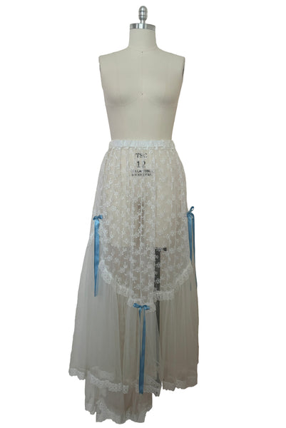 Front view of 1980s vintage sheer white lace & tulle skirt with train, trimmed with blue satin ribbon bows, small, medium, large.