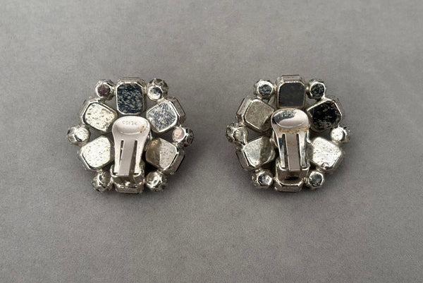 Horizontal back view of 1950s vintage smoke gray rhinestone and silver tone metal round clip-on earrings by Weiss.