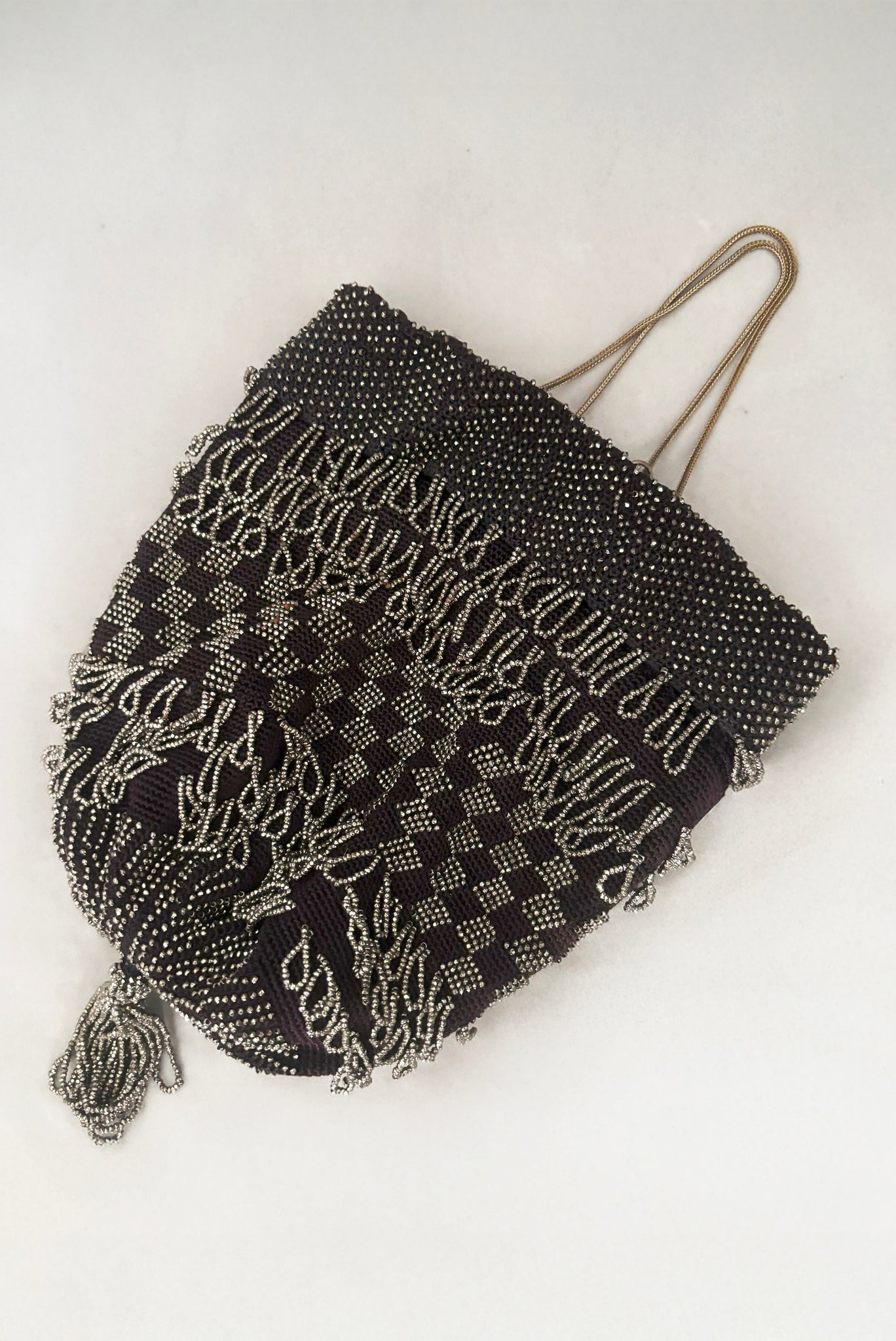 Vertical front view of 1910s turn of the century vintage Edwardian silver gray beaded black crochet drawstring handbag.