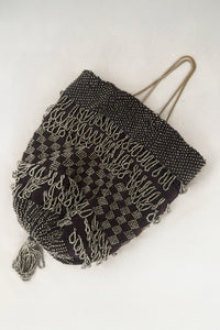 Vertical front view of 1910s turn of the century vintage Edwardian silver gray beaded black crochet drawstring handbag.