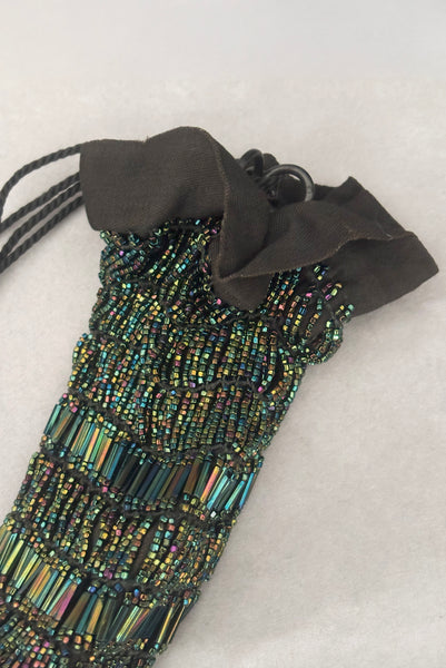 Detail view of 1910s turn of the century vintage Edwardian black peacock iridescent glass beaded drawstring handbag. Showing the black cotton top edge.