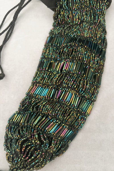 Detail view of 1910s turn of the century vintage Edwardian black peacock iridescent glass beaded drawstring handbag. Showing the iridescent bugle and seed beads.