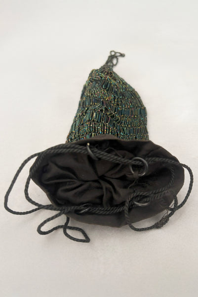 Vertical top view of 1910s turn of the century vintage Edwardian black peacock iridescent glass beaded drawstring handbag. Showing the wooden rings and cord that create the drawstring top and a peek at the black cotton lining.