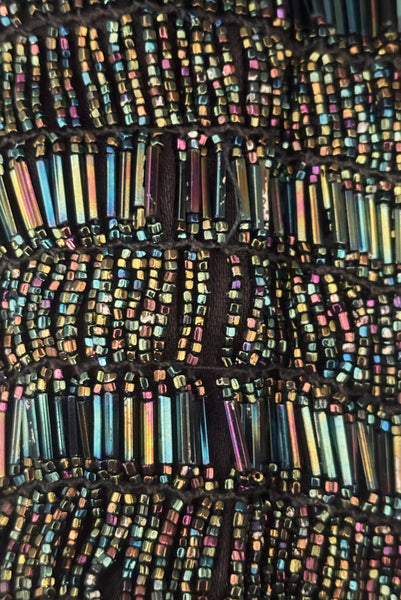 Detail view of 1910s turn of the century vintage Edwardian black peacock iridescent glass beaded drawstring handbag. Showing a small area of missing beading.