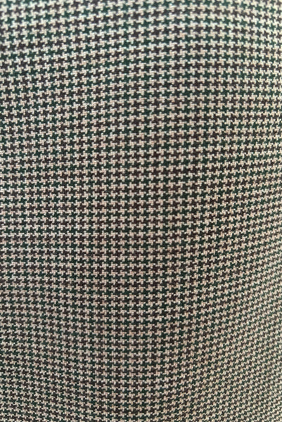 Fabric detail of 1990s brown, green, and white wool houndstooth pegged pencil skirt with inseam pockets by Chaiken and Capone, small to medium.