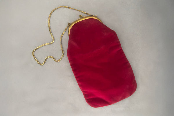 Horizontal styled view of 1960s vintage rose pink velvet evening handbag with gold frame and chain handle, by Morris Moskowitz.