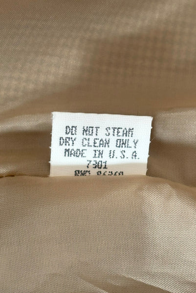 Tag view of 1990s brown, green, and white wool houndstooth pegged pencil skirt with inseam pockets by Chaiken and Capone, small to medium, showing the care instructions. Dry clean only.