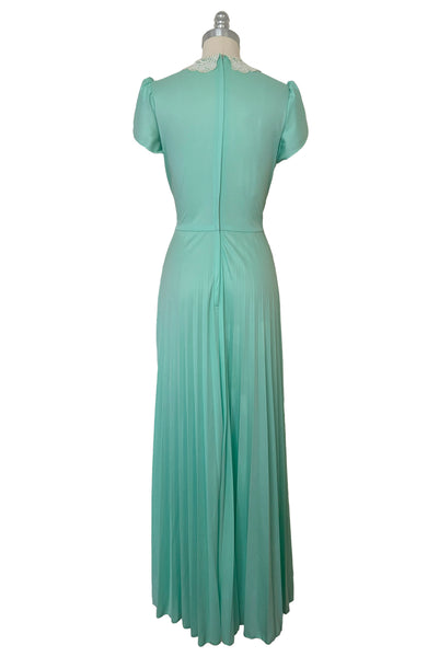 Back view of 1970s vintage mint green knit maxi dress with lace peter pan collar, tulip sleeves, pintucked bodice, and pleated skirt, small to medium.