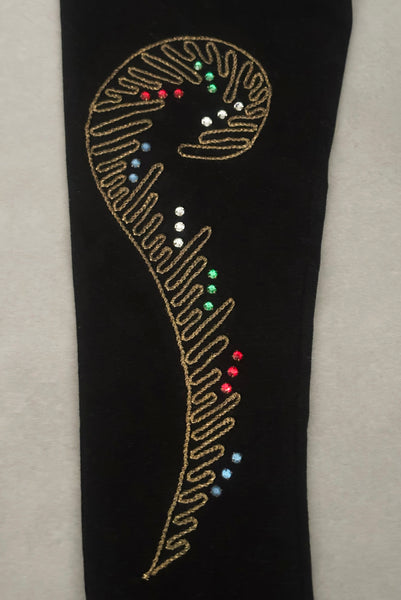 Detail view of 1950s vintage black mid length gloves with clear, red, blue, & green prong set rhinestone and gold work embroidery by Lady Gay, size 7. Showing a close-up of the curling fern frond gold metal embroidery with surrounding rhinestones.