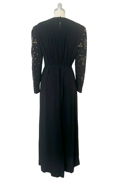 Back view of 1930s vintage black rayon crepe evening gown with statement sleeves beaded with glass beads and brass sequins, small to medium.