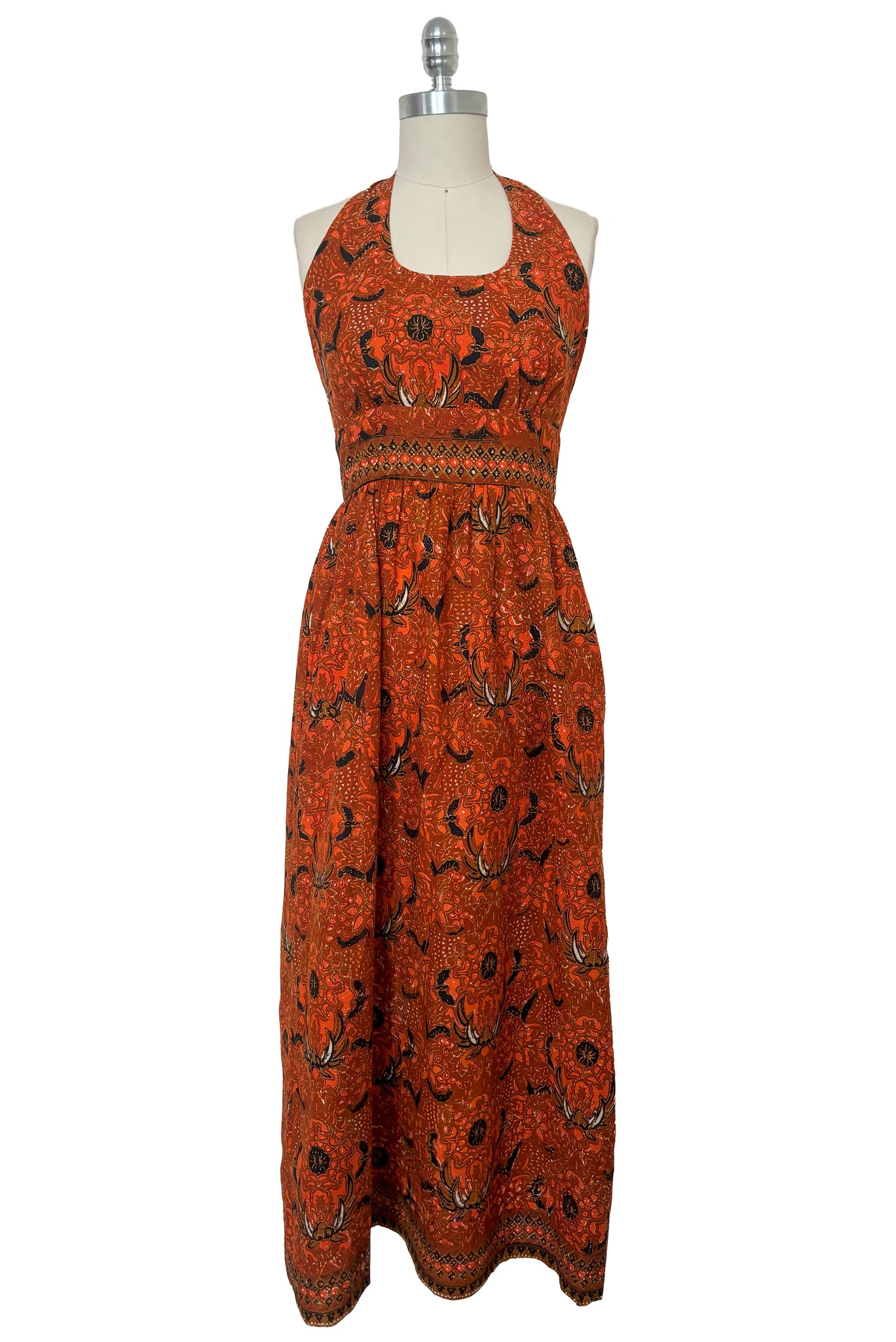 Front view of  1970s vintage orange and black Halloween bat and spider wax print cotton maxi dress with halter neckline, extra small to small.