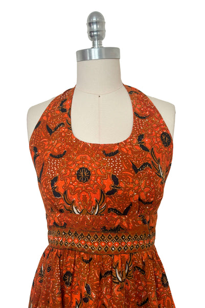 Bodice front view of 1970s vintage orange and black Halloween bat and spider wax print cotton maxi dress with halter neckline, extra small to small.