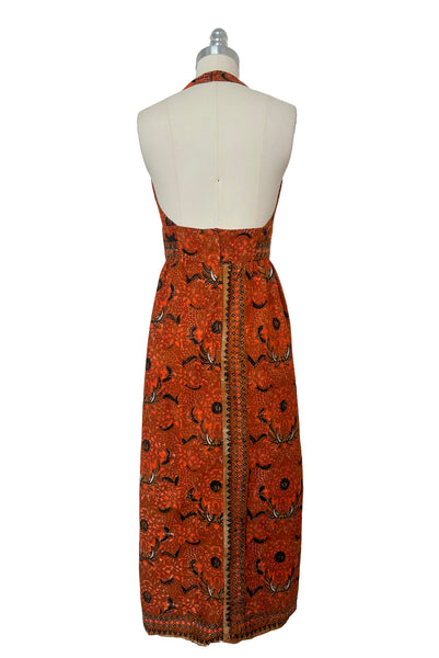 Back view of 1970s vintage orange and black Halloween bat and spider wax print cotton maxi dress with halter neckline, extra small to small.