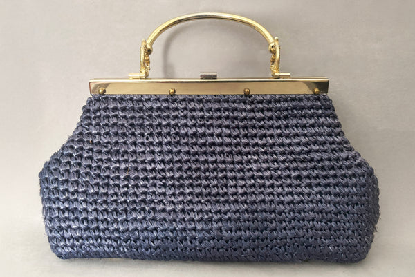 Horizontal back view of 1950s periwinkle blue crochet raffia straw handbag with ornate gold tone metal handle, by Simon, made in Japan.
