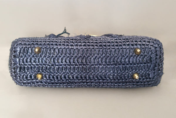 Horizontal bottom view of 1950s periwinkle blue crochet raffia straw handbag with ornate gold tone metal handle, by Simon, made in Japan.