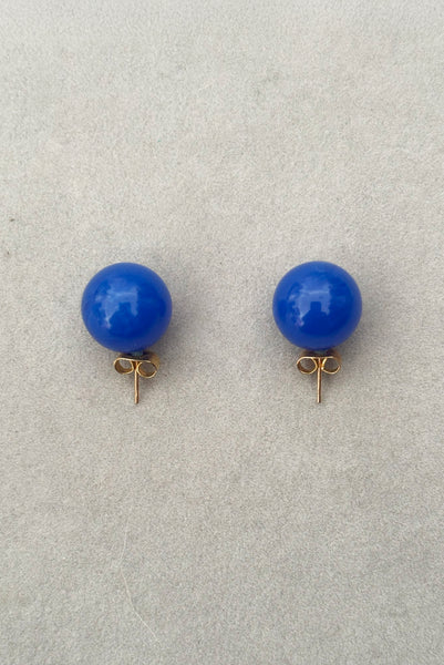 Vertical top view of 1980s vintage bright blue Lucite gumball stud pierced earrings.