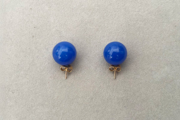 Horizontal top view of 1980s vintage bright blue Lucite gumball stud pierced earrings.