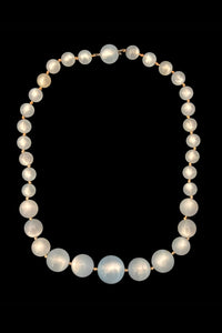 Vertical view of 1950s vintage pale blue moonglow plastic graduated bead necklace.