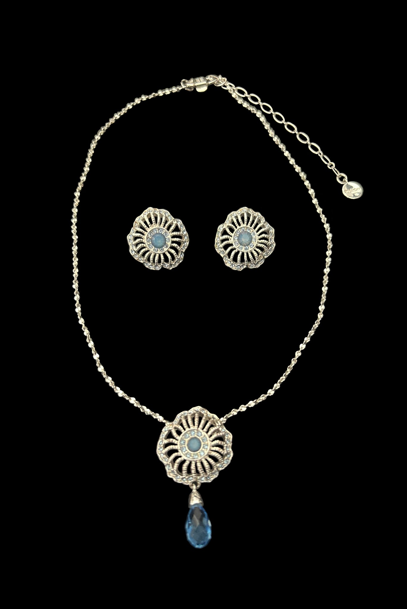 Vertical front view of early 2000s vintage silver tone, blue opaline rhinestone, and crystal floral adjustable necklace and pierced stud earrings jewelry set by Givenchy.