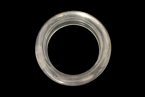 Horizontal top view of 1980s vintage clear Lucite asymmetrical bangle bracelet.