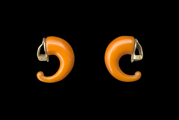 Horizontal side view of 1930s vintage butterscotch French Bakelite half hoop clip-on earrings.
